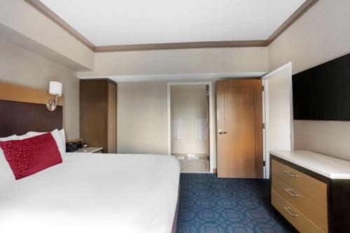 a bedroom with a large bed with a red pillow at Hilton Club New York in New York