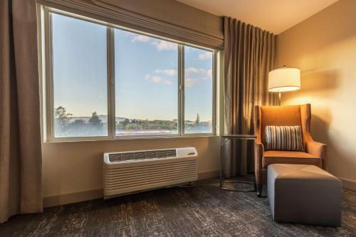 a hotel room with a chair and a window at Hilton Garden Inn Fairfield in Fairfield