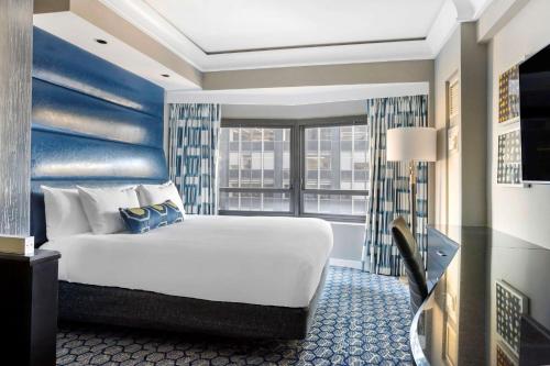 a hotel room with a bed and a large window at Hilton Club New York in New York