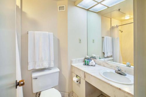a bathroom with a sink and a toilet and a mirror at Hilton Oakland Airport in Oakland