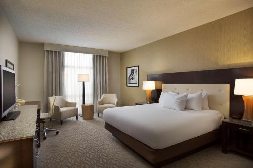 una camera d'albergo con letto e TV di Hilton Oakland Airport a Oakland
