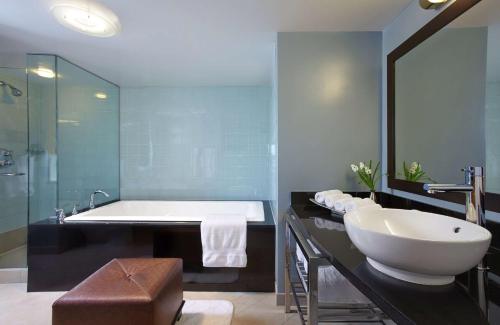 a bathroom with a large tub and a sink at Hilton Club New York in New York