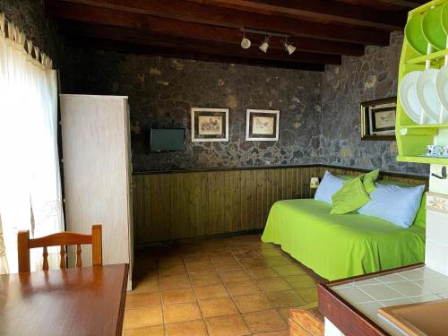 sypialnia z zielonym łóżkiem w pokoju w obiekcie Estudio Rural de Piedra w mieście Frontera