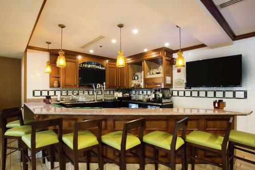 a kitchen with a large bar with yellow chairs at Hilton Garden Inn Fairfield in Fairfield