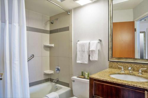 a bathroom with a tub and a sink and a toilet at Hilton Chicago/Oak Lawn in Chicago