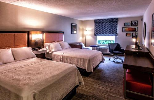 una camera d'albergo con 2 letti e una scrivania di Hampton Inn & Suites Staten Island a Staten Island