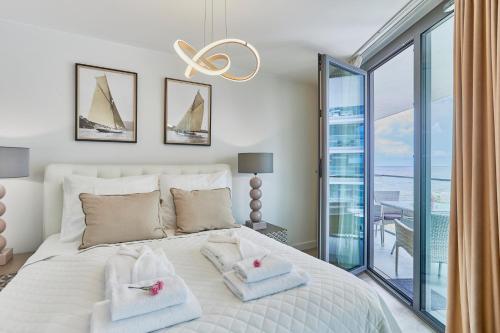 a bedroom with a large bed with towels on it at Wave Prestige Studio - Sea View - SPA&Pools in Międzyzdroje