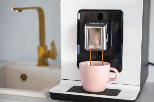 a coffee maker with a cup on a counter at SOLEK Apartamenty i pokoje gościnne in Mielno