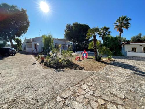 ヴィエステにあるAppartamenti "Le Porte del Gargano" ex residence maddalenaの木の庭と建物のある砂利の私道
