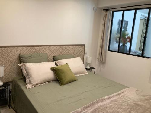 - une chambre avec un lit avec deux oreillers et une fenêtre dans l'établissement Les restanques de la Panouse, à Marseille