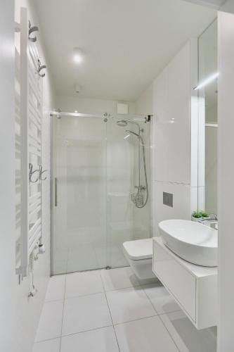 a bathroom with a shower and a toilet and a sink at Wave Prestige Studio - Sea View - SPA&Pools in Międzyzdroje
