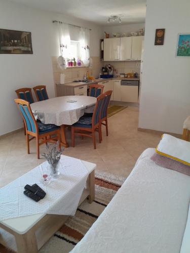 cocina y sala de estar con mesa y sillas en Apartments Biočić, en Korčula