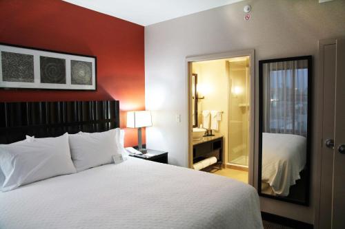 a hotel room with a bed and a bathroom at Embassy Suites Ontario - Airport in Ontario