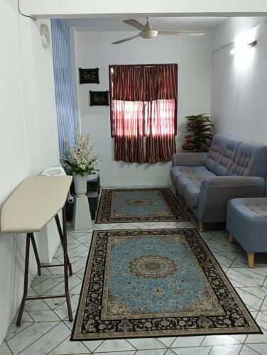 a living room with a couch and a table and rug at KHAIRUL HOMESTAY SEBERANG JAYA in Kampong Telok