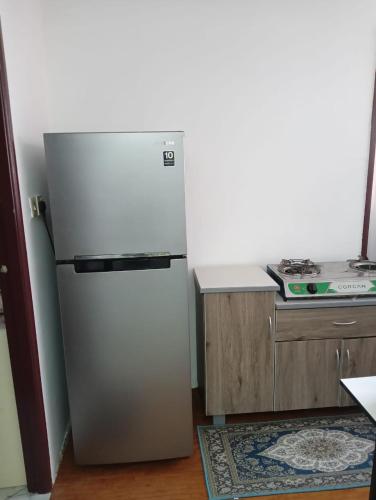 a refrigerator in the corner of a kitchen at KHAIRUL HOMESTAY SEBERANG JAYA in Kampong Telok