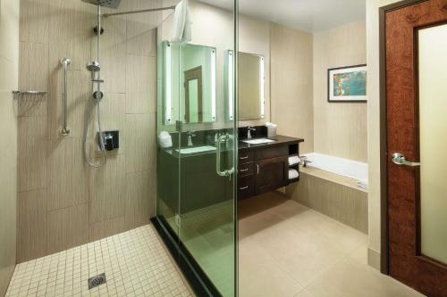 y baño con ducha acristalada y lavamanos. en DoubleTree by Hilton Claremont, en Claremont