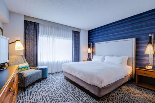 um quarto de hotel com uma cama grande e uma cadeira em DoubleTree Suites by Hilton Hotel & Conference Center Chicago-Downers Grove em Downers Grove