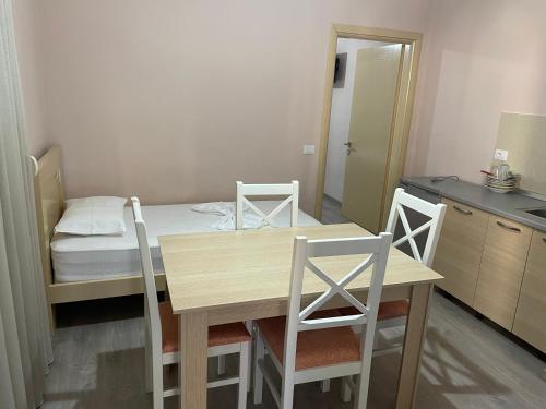 a kitchen with a table and chairs and a bed at Rent Rooms Kapri in Pogradec