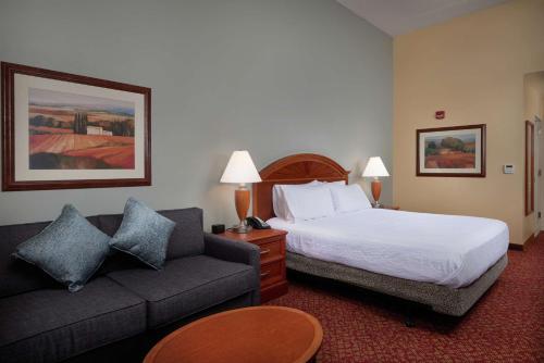 um quarto de hotel com uma cama e um sofá em Hilton Garden Inn Newport News em Newport News