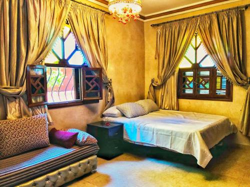 1 dormitorio con cama, sofá y ventanas en Villa mogador, en Essaouira