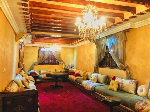 una sala de estar con sofás y una lámpara de araña. en Villa mogador, en Essaouira