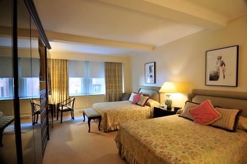 um quarto de hotel com duas camas e uma cadeira em Lombardy Hotel em Nova Iorque