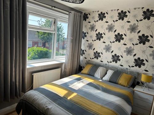 una camera con un letto di fronte a una finestra di 2 bedroom house close to city centre with gated driveway a Liverpool