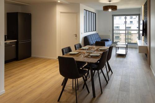 a dining room and living room with a table and chairs at Clermont Hyper Centre & Parking in Clermont-Ferrand