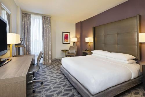 a hotel room with a large bed and a desk at DoubleTree by Hilton Orlando East - UCF Area in Orlando