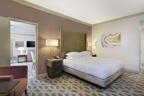 a hotel room with a bed and a mirror at DoubleTree by Hilton Orlando East - UCF Area in Orlando