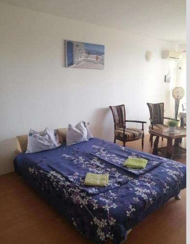 a bedroom with a bed with a blue blanket on it at Rose Apartment on the Beach in Byala