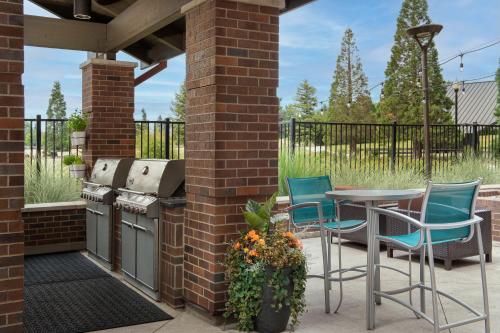a patio with a grill and chairs and a table at TownePlace Suites by Marriott Portland Vancouver in Evergreen