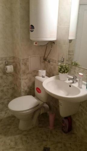 a bathroom with a toilet and a sink at Rose Apartment on the Beach in Byala