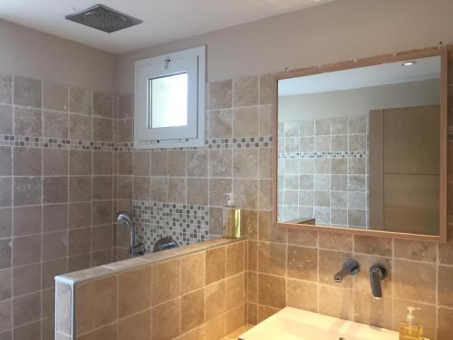 une salle de bain avec un lavabo et un miroir dans l'établissement Au coeur du bassin...à vélo, au Teich