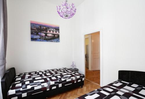 a bedroom with two beds and a chandelier at Apartment near the Charles Bridge in Prague