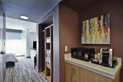 a hotel room with a kitchen with a microwave at Hilton Garden Inn Panama City in Panama City