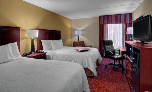 um quarto de hotel com duas camas e uma televisão de ecrã plano em Hampton Inn Newport News-Yorktown em Newport News