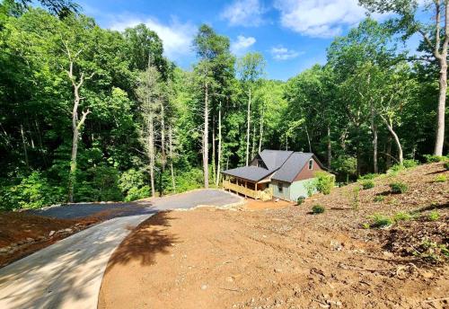 a house on the side of a dirt road at Sliding Rock -A Creekside Cottage w7 acres, Waterfalls & Hiking in Old Fort