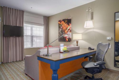 a hotel room with a desk and a chair at Hilton Garden Inn Phoenix Airport in Phoenix