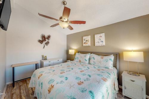 a bedroom with a bed and a ceiling fan at Madeira Beach Yacht Club #G in St. Pete Beach