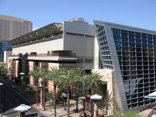 a large building with palm trees in front of it at Hilton Phoenix Airport in Phoenix