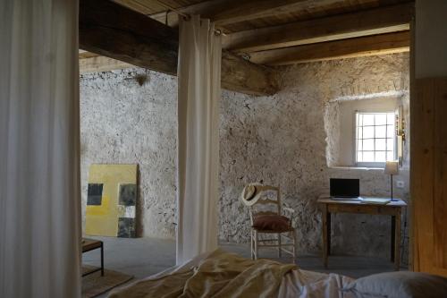 Sant Jordi Desvalls的住宿－CAN TAT, Loft in a old coach house，一间卧室配有一张床、一张书桌和一个窗户。