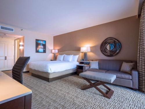 a hotel room with a bed and a couch at Hilton Phoenix Airport in Phoenix