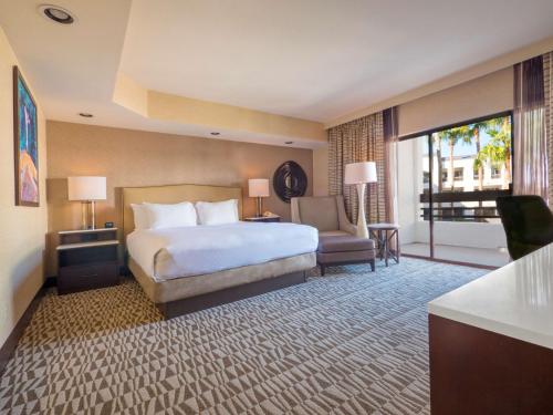 a hotel room with a bed and a balcony at Hilton Phoenix Airport in Phoenix