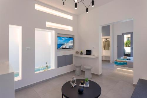 a living room with white walls and windows at Linea Luxury Suites in Fira