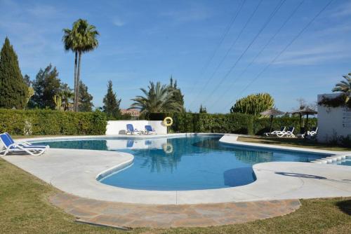 a swimming pool with two lounge chairs in a yard at Golfer Paradise next to La Quinta Golf Club RDR319 in Benahavís