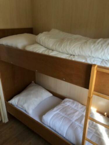 two bunk beds in a room with a ladder at Waterchalet number 6 Recreationpark Yn'e Lijte Grou met ligplaats boot in Grou