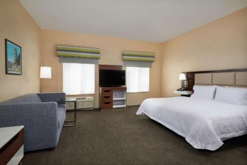 um quarto de hotel com uma cama e um sofá em Hampton Inn & Suites Phoenix-Surprise em Surprise