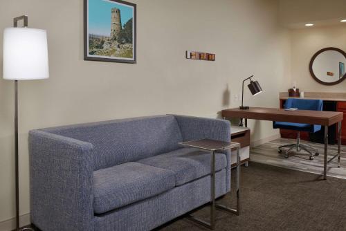 a living room with a blue couch and a desk at Hampton Inn & Suites Phoenix-Surprise in Surprise