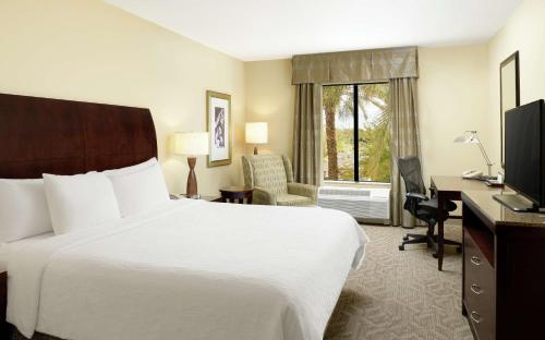 a hotel room with a bed and a desk and a television at Hilton Garden Inn Phoenix North Happy Valley in Phoenix